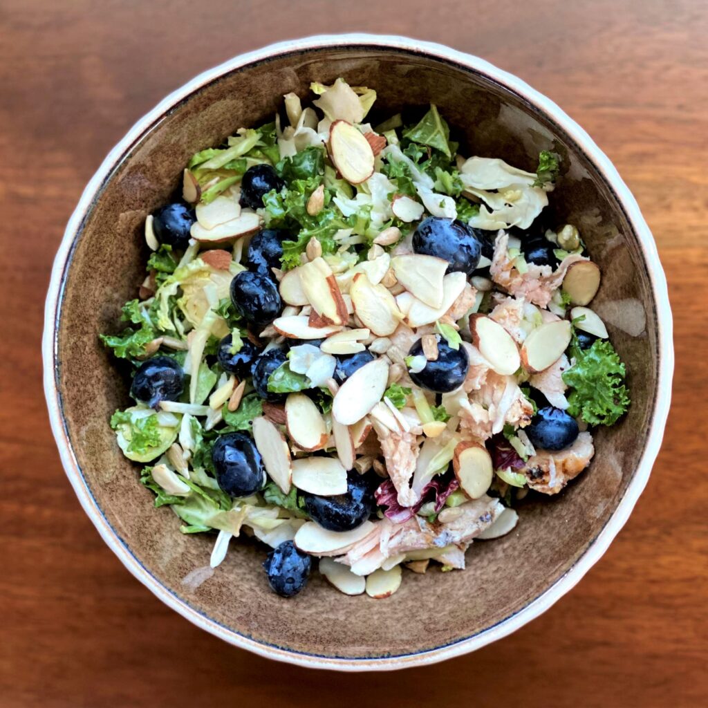 Sweet kale salad with blueberries, chicken, and sliced almonds